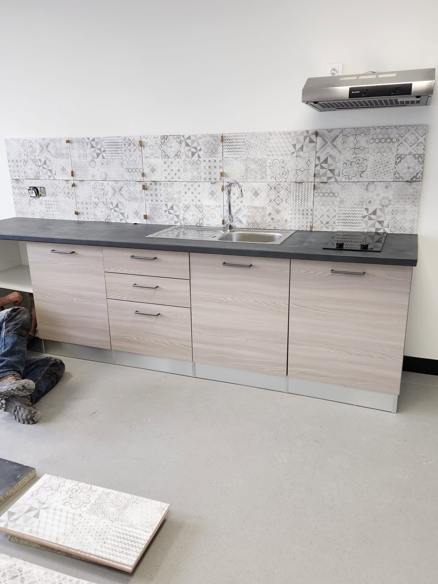 Salle de bain & Carrelage — Cuisine équipée : crédence en faïence à motifs et plan de travail minéral